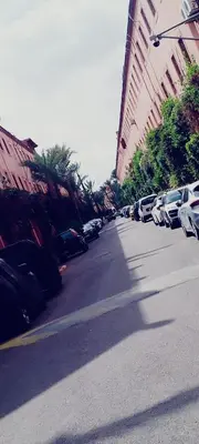 a city street with parked cars and buildings at Riad DarDamia in Marrakech