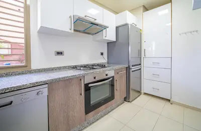 a kitchen with a stove and a refrigerator at Central & comfy 3BR apartment with pool & wifi access in Marrakech