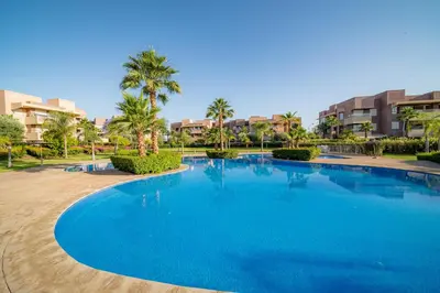 a large blue swimming pool in a resort at Central & comfy 3BR apartment with pool & wifi access in Marrakech