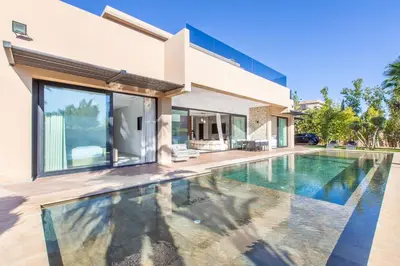 a swimming pool in front of a house at Villa Rafinity Marrakech in Marrakech