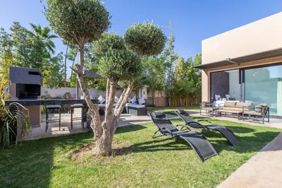 a yard with a group of chairs and a tree at Palais Rafi in Marrakech