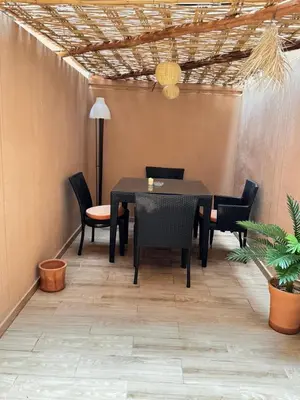 a dining room with a black table and chairs at Cosy & magnifique appartement Marrakech in Marrakech