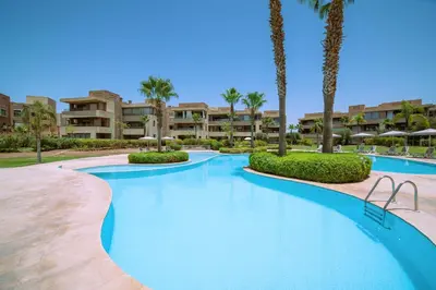 a swimming pool at a resort with palm trees and condos at Exceptional Style Nonstop Luxury in Marrakech