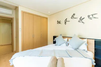 a bedroom with a bed with two feet on it at Relax Front Of Pool-Garden-Fibre in Marrakech