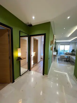 a room with green walls and a hallway with mirrors at Luxe appartement à louer pour les familles in Marrakech