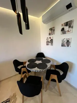 a dining room with a table and chairs at Luxe appartement à louer pour les familles in Marrakech