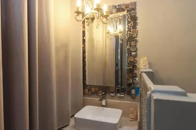 a bathroom with a sink and a toilet and a mirror at Riad Garden House Marrakech in Marrakech