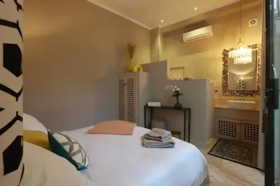 a room with a bed and a bathroom with a mirror at Riad Garden House Marrakech in Marrakech