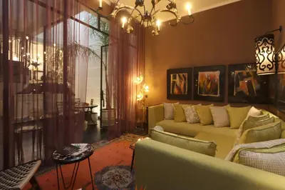 a living room with a couch and a chandelier at Riad Garden House Marrakech in Marrakech