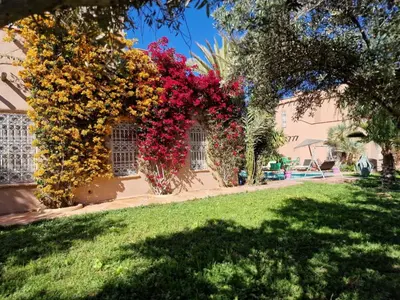 a house with flowers on the side of it at Manzal Lahbab, 2Villas 2Bungalows 2Piscines et Jardins in Marrakech