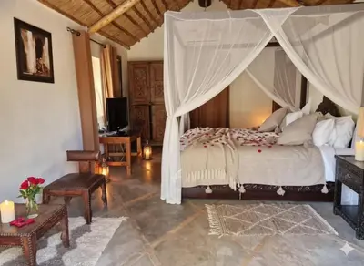 a bedroom with a large bed with a canopy at Manzal Lahbab, 2Villas 2Bungalows 2Piscines et Jardins in Marrakech