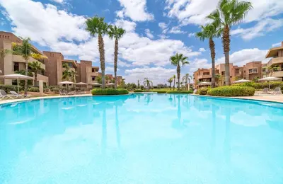 a large swimming pool with palm trees and buildings at Relaxing Summer-Pool-Garden-Wifi in Marrakech