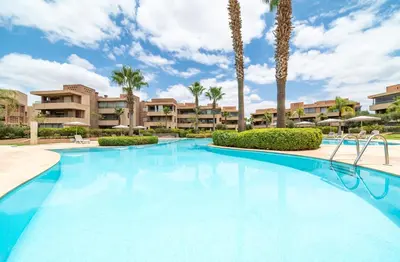 a large swimming pool with palm trees and buildings at Relaxing Summer-Pool-Garden-Wifi in Marrakech
