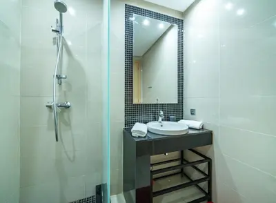 a bathroom with a sink and a shower with a mirror at Relaxing Summer-Pool-Garden-Wifi in Marrakech