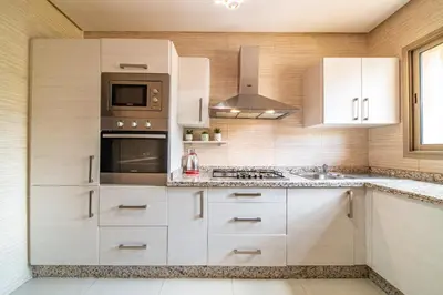 a kitchen with white cabinets and a stove top oven at Relaxing Summer-Pool-Garden-Wifi in Marrakech