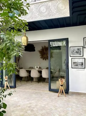a room with a table and chairs and a door at Riad Wadiya, privatif, piscine en rooftop. in Marrakech