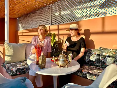 two women sitting at a table on a patio at Riad 11 Zitoune in Marrakech