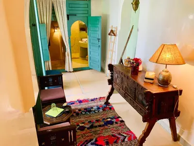 a room with a table and a lamp and a mirror at Riad 11 Zitoune in Marrakech