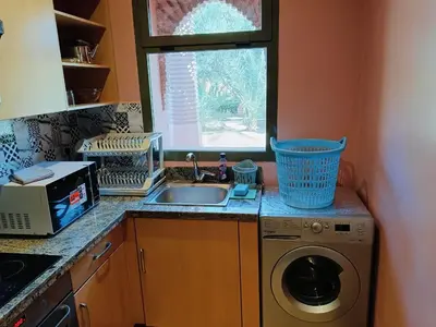 a kitchen with a sink and a washing machine at Appartements de charme à la palmeraie in Marrakech
