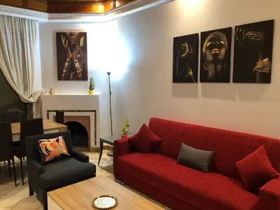 a living room with a red couch and a table at Appartements de charme à la palmeraie in Marrakech