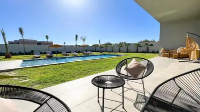 a patio with two chairs and a swimming pool at Villa KOEUR, piscine chauffée sans vis-à-vis à Marrakech in Marrakech