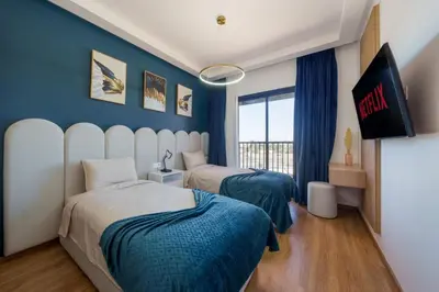 two beds in a room with blue walls at Belle vue, noria golf in Marrakech
