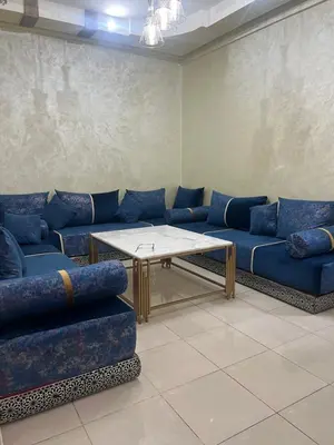 a living room with blue couches and a table at Confort Abordable Louez Notre Appartement in Marrakech