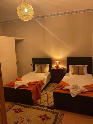 a bedroom with two beds and a chandelier at Riad212 private medina fast Wi-Fi plunge pool in Marrakech