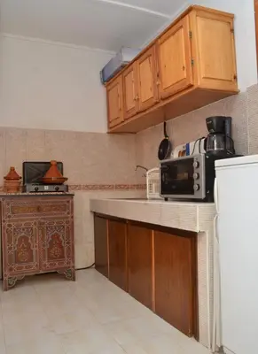 a kitchen with wooden cabinets and a microwave at Cheap accommodation in Marrakech in Marrakech