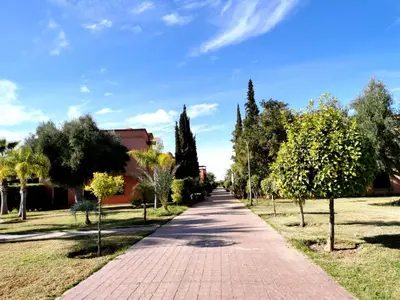 a brick path in a park with trees at Cozy apartment with roof top in Marrakech
