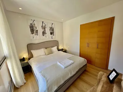 a bedroom with a bed and a wooden door at New appart, pool and golf view in Marrakech