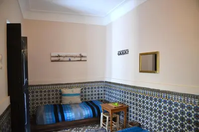 a room with a bed and a mirror on the wall at Dar Mirai in Marrakech