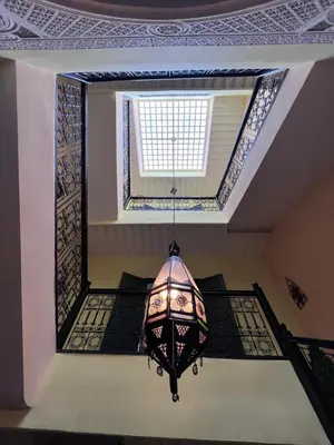 a chandelier hanging from a ceiling with a window at Riad Paolo Piscine Palmeraie in Marrakech
