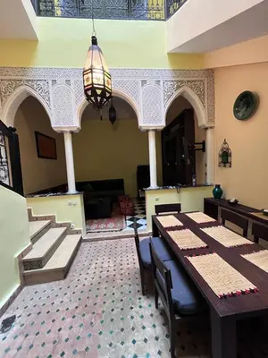 a dining room with a table and a chandelier at Riad Paolo Piscine Palmeraie in Marrakech