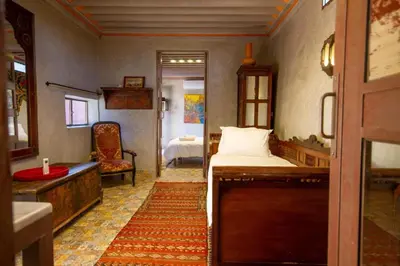 a bedroom with a bed and a bathroom with a sink at La Ferme de LallaDom in Tameslouht
