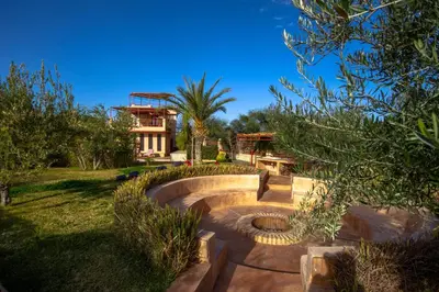 a garden with a stone amphitheater in front of a house at La Ferme de LallaDom in Tameslouht