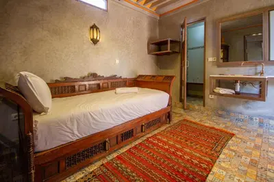 a bedroom with a wooden bed in a room at La Ferme de LallaDom in Tameslouht