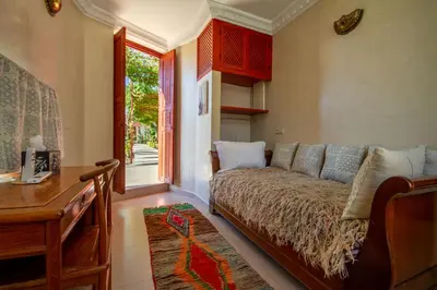 a living room with a couch and a desk at La Ferme de LallaDom in Tameslouht