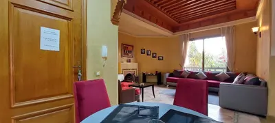a living room with a couch and a table and chairs at Les Jardins de la palmeraie in Marrakech