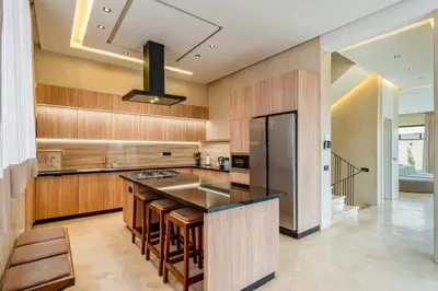 a kitchen with wooden cabinets and a black counter top at Villa Tolède by TheCasaEdition in Marrakech