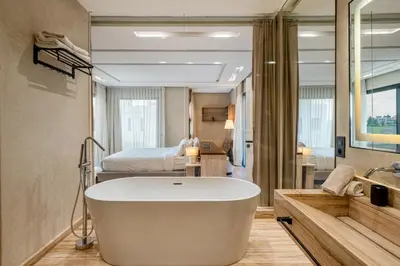 a bathroom with a bath tub and a bed at Villa Tolède by TheCasaEdition in Marrakech