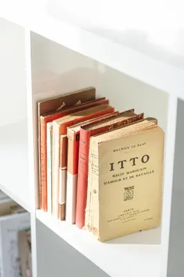 a row of books sitting on a shelf at Appartement Uniquement Familial 2 Chambres spacieux cosy, calme in Marrakech