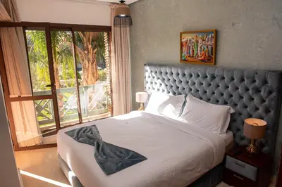a bedroom with a bed and a large window at Tibouda House Deluxe Avec Piscine - Familiale in Marrakech