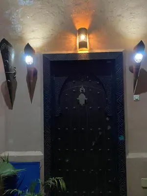a black door with two lights above it at Riad Ayiss piscine palmeraie in Marrakech
