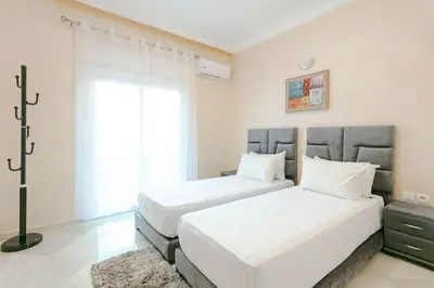 a bedroom with two beds and a window at Modern Odyssey – Marrakech Centre in Marrakech
