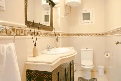 a bathroom with a sink and a toilet and a mirror at Modern Odyssey – Marrakech Centre in Marrakech