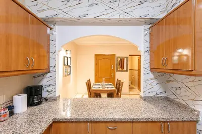 a kitchen with a table and a dining room at Modern Odyssey – Marrakech Centre in Marrakech