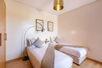 a bedroom with two beds and a couch at luxueux & spacieux appartement a prestigia in Marrakech
