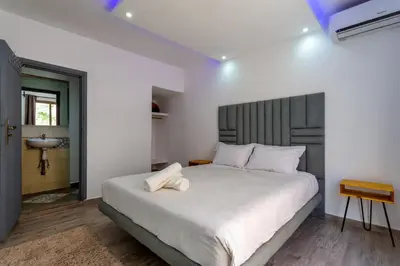 a bedroom with a large white bed and a sink at Villa privée avec piscine Sans vis-à-vis, calme absolu in Marrakech