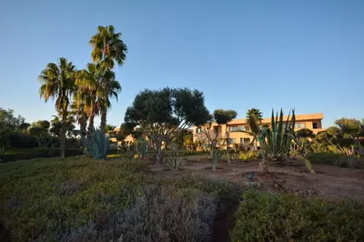 a resort with palm trees and a building in the background at Luxueux Duplex 2CH dans une magnifique résidence in Marrakech